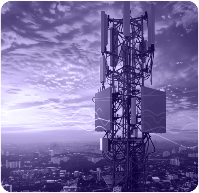 A multi-band cellular tower above a city skyline, with signal traces across it